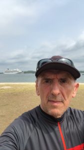 Paul the Dinosaur getting on his bike as he begins a new life cycle on how to use AI to make money after 50