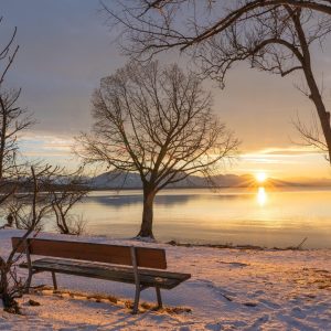 Winter sun setting over a frosty landscape, a darkening sky and quiet horizon.