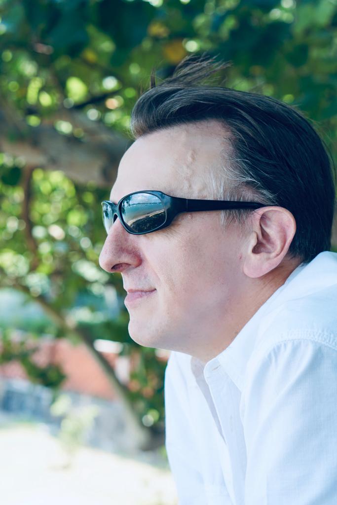 Paul the Dinosaur looking ahead outdoors in sunglasses, representing forward focus and a second-act mindset for digital income after 50.